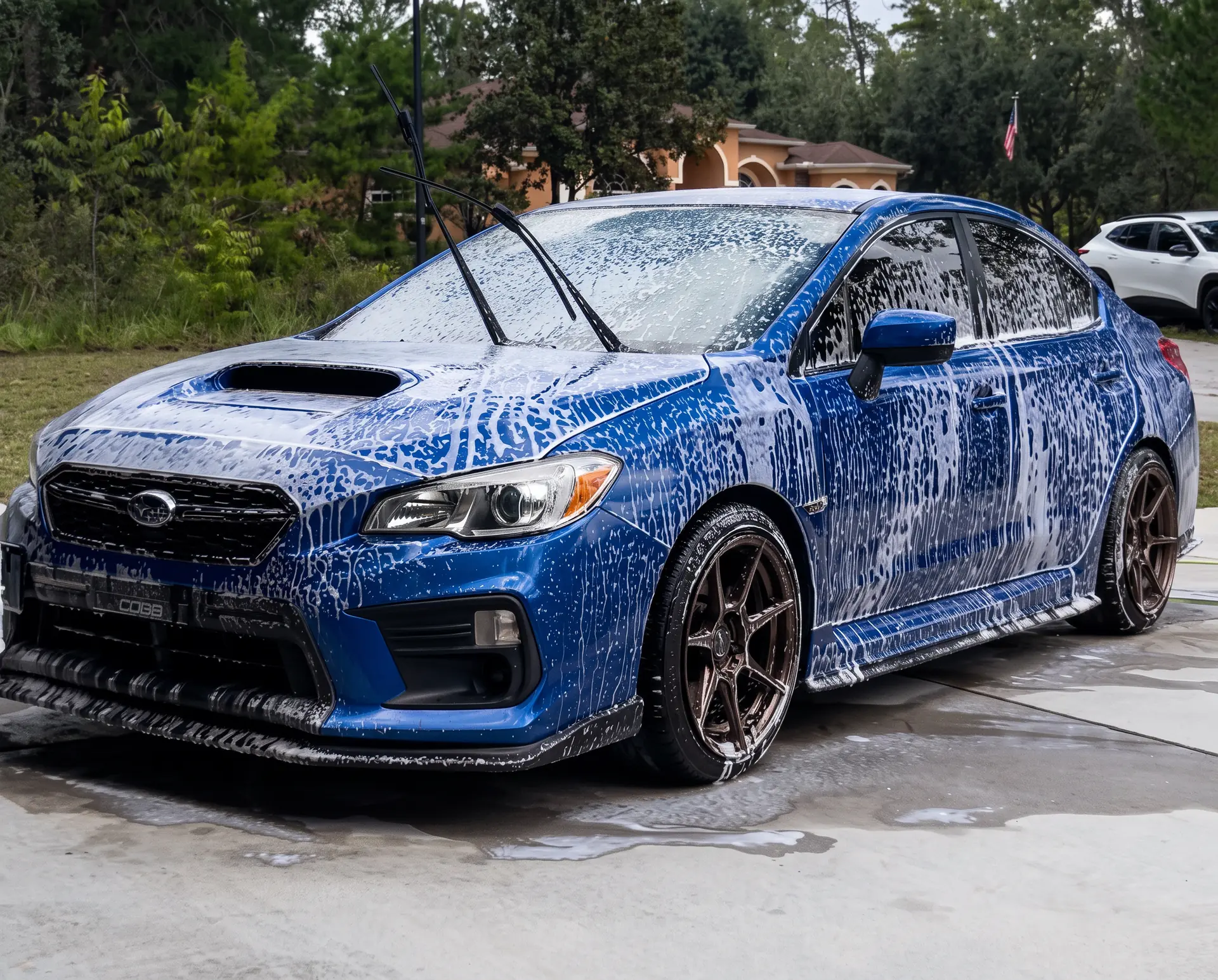 Mobile detailing in Inverness, FL Professional mobile car detailing in Inverness, Florida — blue Subaru WRX covered in foam suds during a premium exterior wash